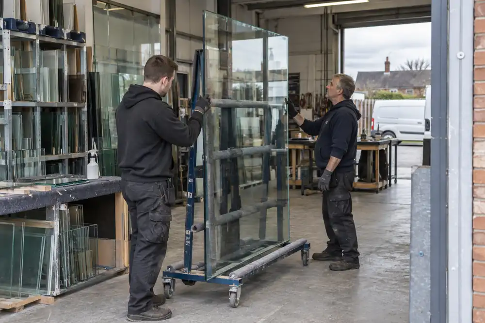 Local glazing staff checking a supported pane in their workshop